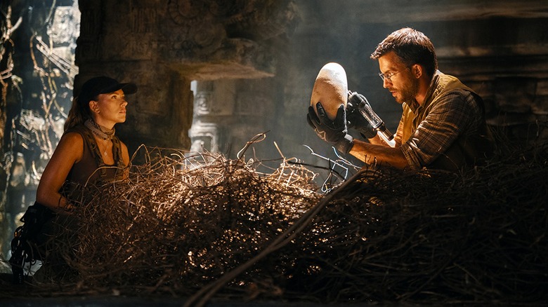 Le Dr Henry Loomis inspectant l'œuf de dinosaure pendant que Zora Bennett regarde