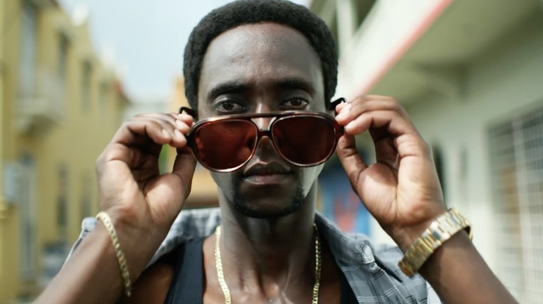 Ronald Dacey (Edi Gathegi) enlevant ses lunettes de soleil 