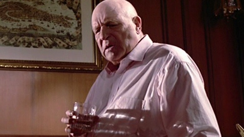 Joe tenant un verre dans un bureau de réservoir Dogs (1992)