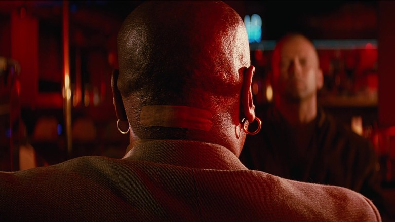 Marsellus Wallace par derrière montrant un grand bandage à l'arrière du cou dans Pulp Fiction (1994)