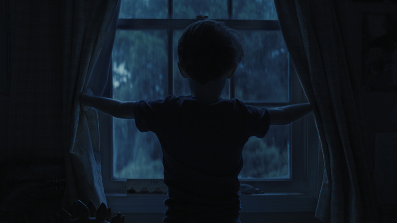 Alex regarde par la fenêtre dans les armes