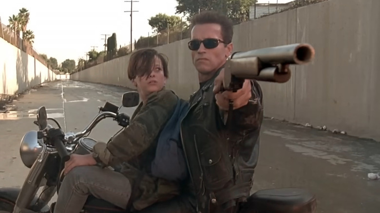 Le T-800 pointe son pistolet sur une moto avec John Connor