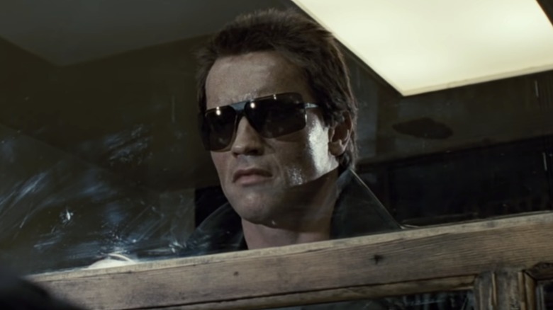 Le T-800 en lunettes de soleil regardant à travers une fenêtre