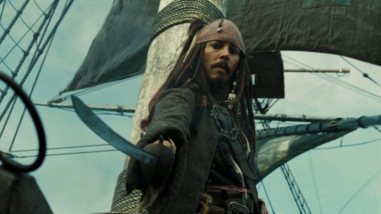 Jack Sparrow dessine son épée tout en s'accrochant au mât "Pirates des Caraïbes: poitrine de l'homme mort" (2006)