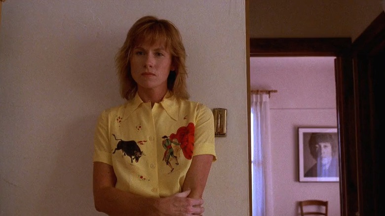 Annie dans une chemise jaune debout contre un mur dans la maison de Kinsella dans Field of Dreams