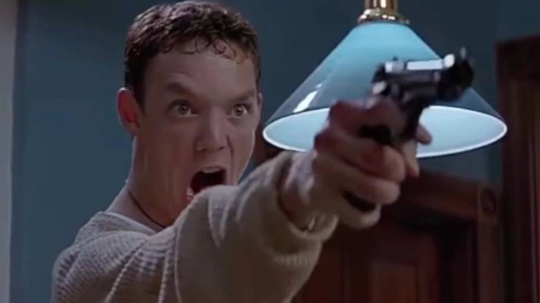 Stu criant tout en tenant une arme