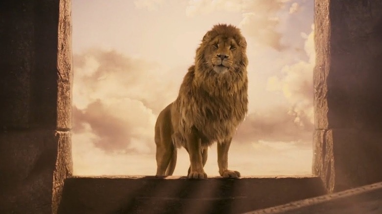 Aslan se tient dans une arche de pierre au soleil 