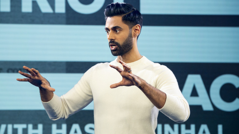 Hasan Minhaj gesticule tout en hébergeant