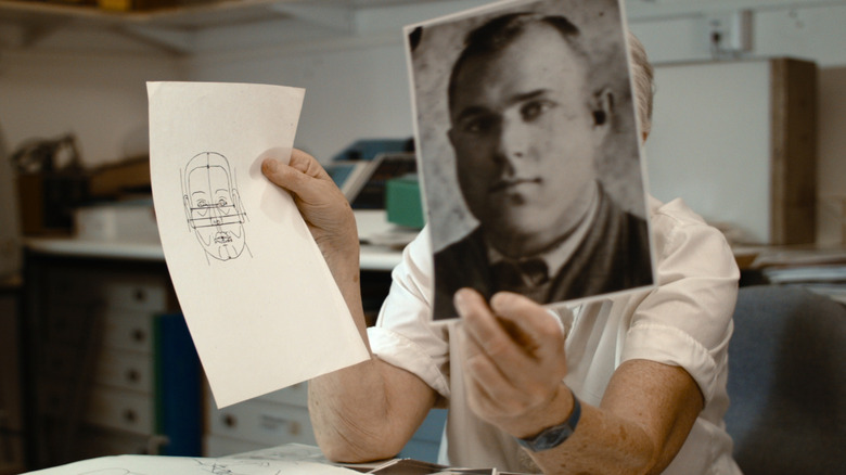 tenant une photo de John Demjanjuk