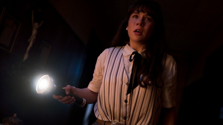 Judy Warren tenant une lampe de poche dans la conjuration: Last Rites (2025)
