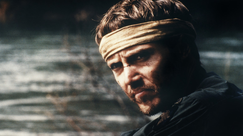Nick portant un bandeau et assis près de l'eau dans le chasseur de cerfs (1978)