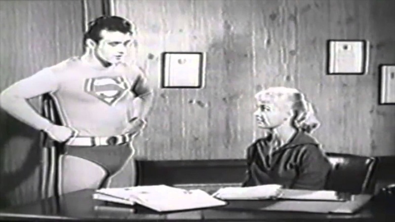 Superboy parle à une fille à un bureau