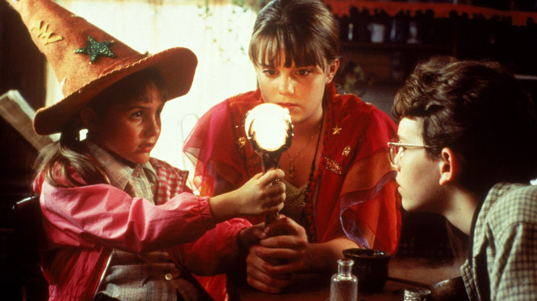 Trois enfants se rassemblant autour d'un orbe brillant à Halloweentown (1998)