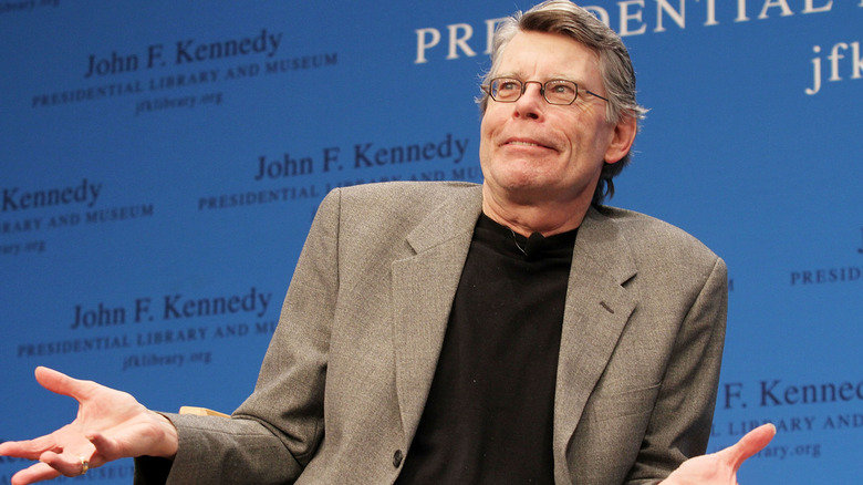 Stephen King levant la main, l'air perplexe