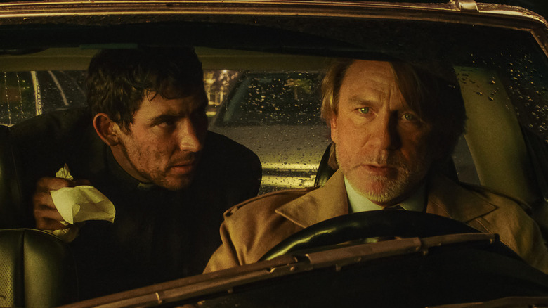 Le révérend Jud Duplenticy et Benoit Blanc assis dans une voiture en