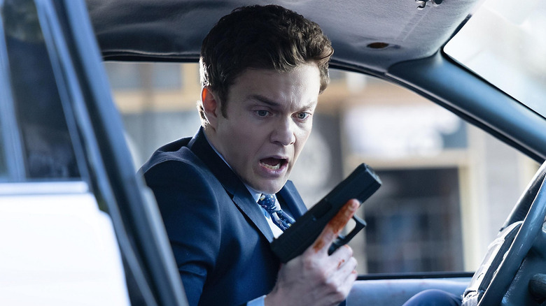 Nathan regardant sa main tenant un pistolet 