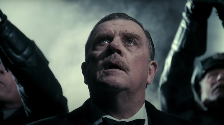 Le commissaire Gordon à nœud papillon lève les yeux