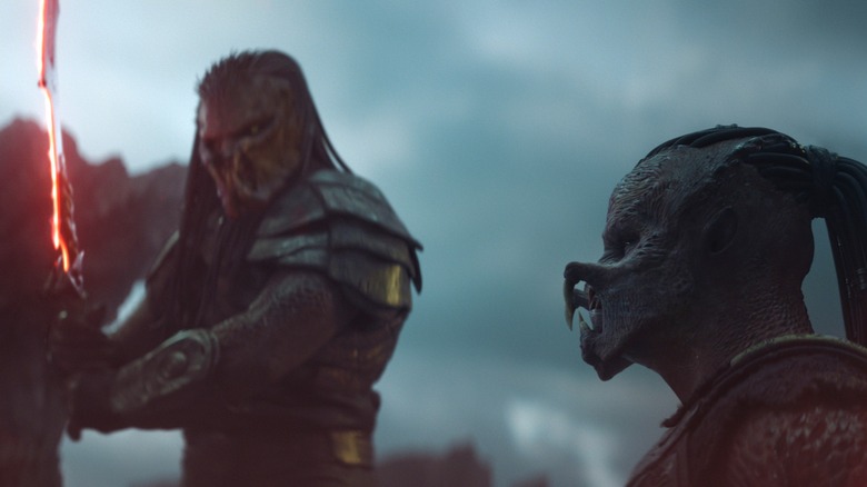 Kwei brandissant une lame près de Dek dans Predator: Badlands