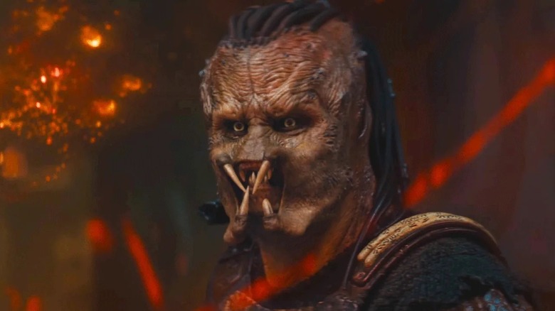 Dek parlant contre une carte de Genna dans Predator : Badlands (2025)