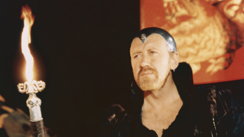 Merlin tenant un bâton de feu dans Excalibur (1981)