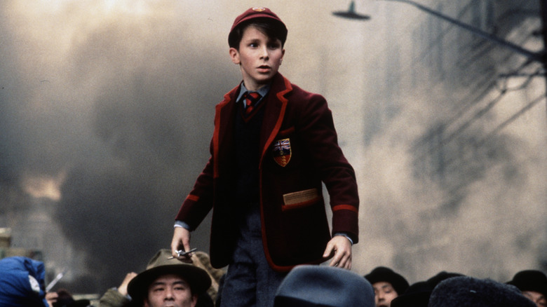 Jim debout au-dessus d'une foule dans Empire of the Sun (1987)