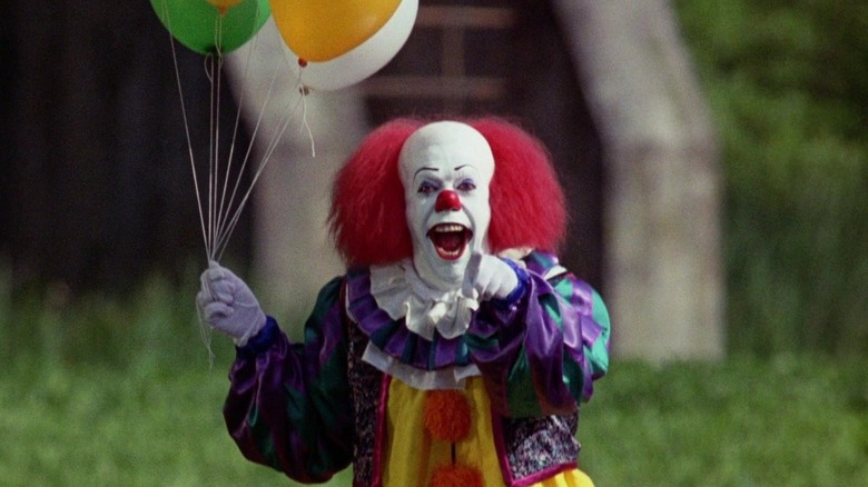Pennywise de Tim Curry rit et le montre du doigt