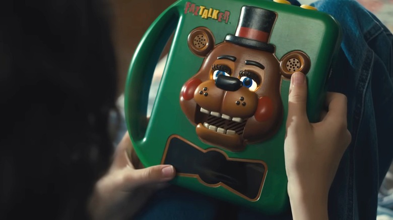 Abby tenant une boîte parlante de Freddy Fazbear "Cinq nuits chez Freddy 2"
