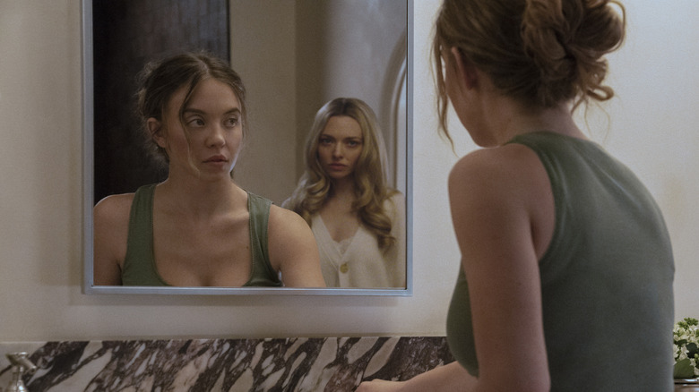 Millie se regarde dans le miroir avec Nina derrière elle dans The Housemaid