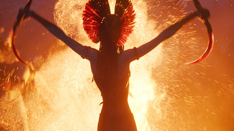 Varang levant ses lames de faucille devant un feu de joie qui fait rage dans Avatar : Fire and Ash