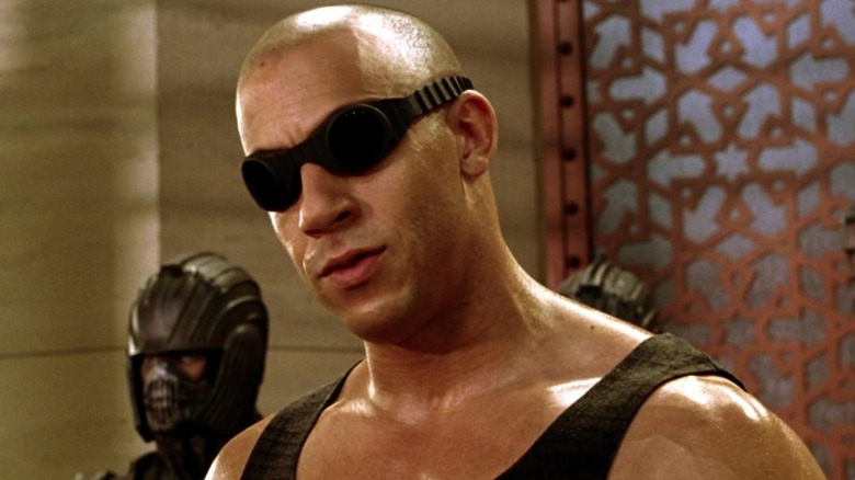 Riddick porte des lunettes et penche la tête sur le côté dans Chronicles of Riddick (2004)