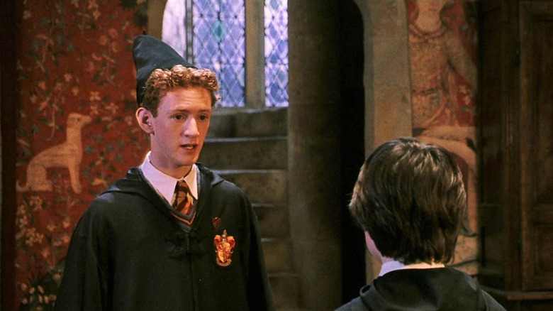 Percy Weasley s'adressant à Harry (face à l'extérieur) en tant que préfet dans la salle commune de Gryffondor