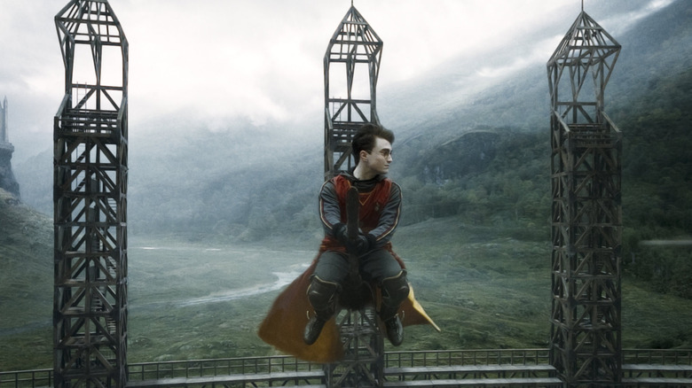 Harry assis sur son balai en l'air lors d'un match de Quidditch sur le terrain de Poudlard