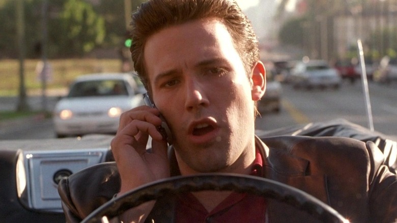 Larry Gigli parlant au téléphone et conduisant à Gigli