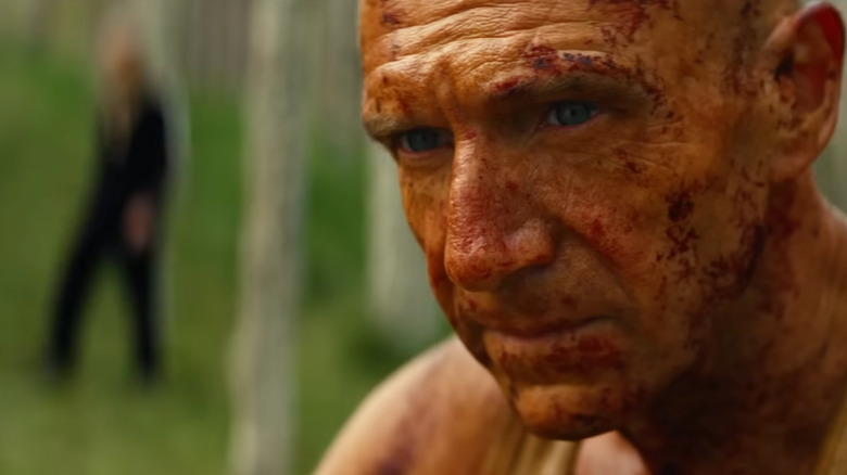 Le Dr Ian Kelson s'assoit avec Jimmy caché en arrière-plan dans 28 ans plus tard : Le Temple des Os