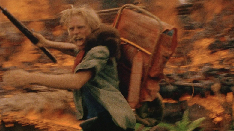 Jack Anders criant devant un feu 