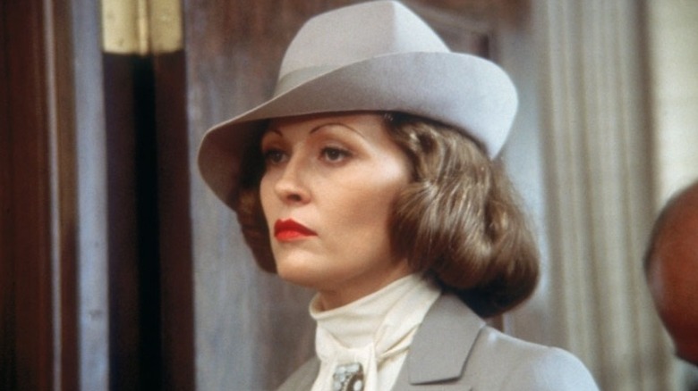 Evelyn Cross Mulwray a l'air sérieuse avec un chapeau