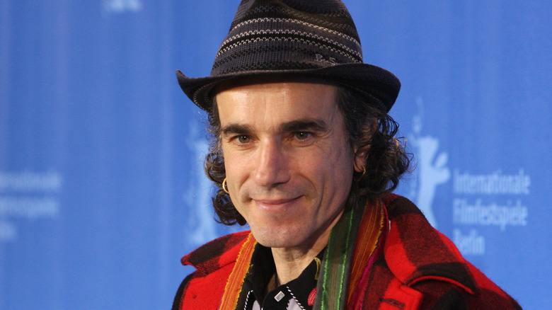 Daniel Day-Lewis avec un chapeau et une flanelle rouge