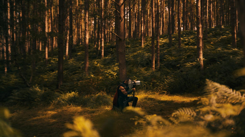 Thor agenouillé dans une forêt avec Stormbreaker dans Avengers : Doomsday
