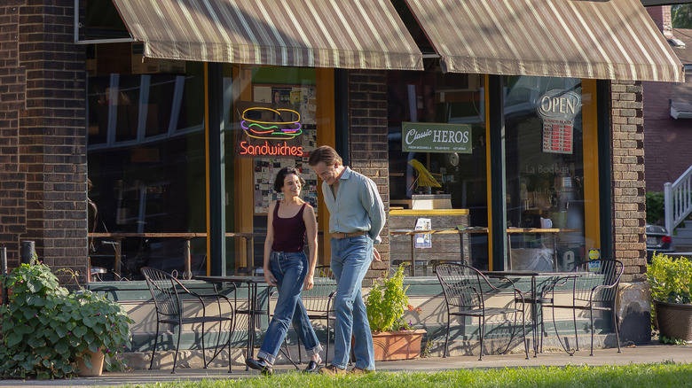 Rebecca et Noah passant devant une sandwicherie à