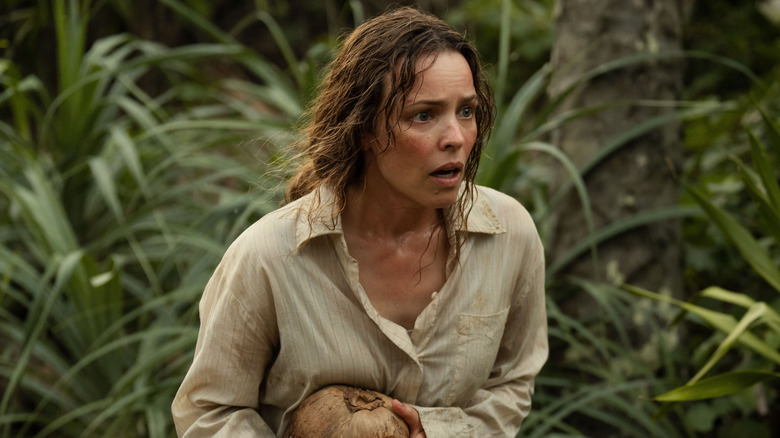 Linda marchant nerveusement dans la jungle en tenant une noix de coco