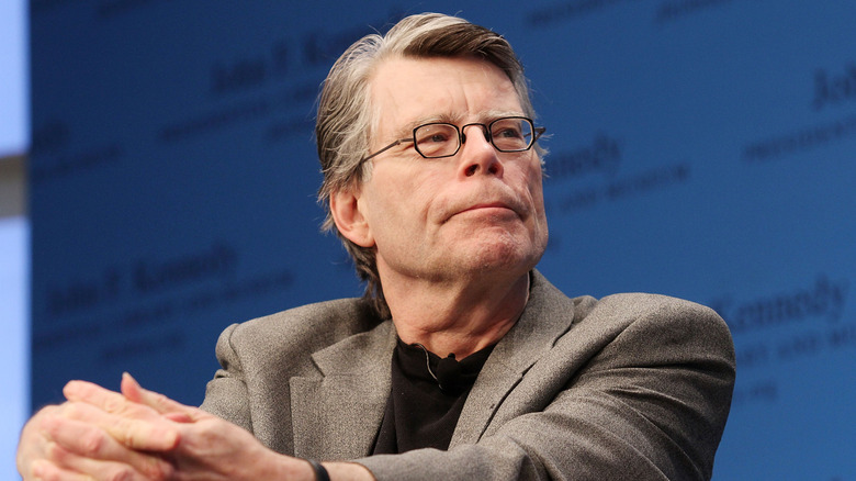 Stephen King assis, les mains sur les genoux