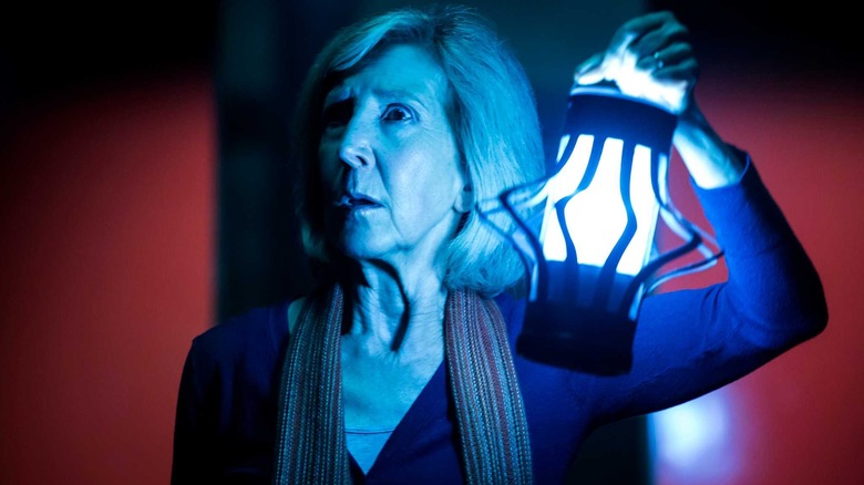 Elise Rainier brandissant une lanterne dans Insidious : Chapitre 3