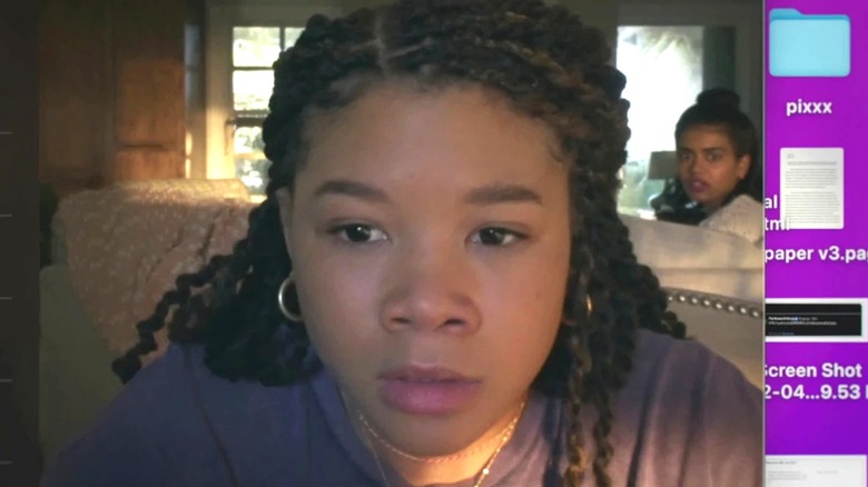 Sky regarde son écran avec son amie Veena assise sur le canapé. 