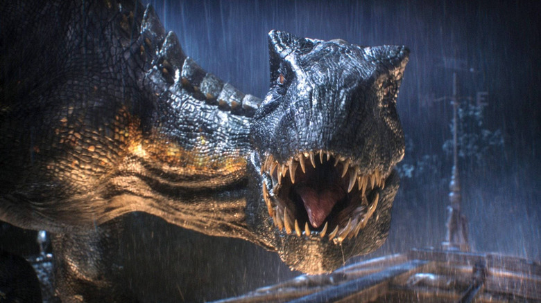 L'Indoraptor rugissant contre sa proie sous la pluie