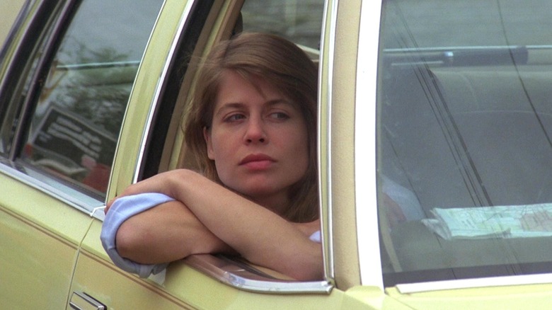 Vicky regardant par la fenêtre d'une voiture jaune dans Children of the Corn