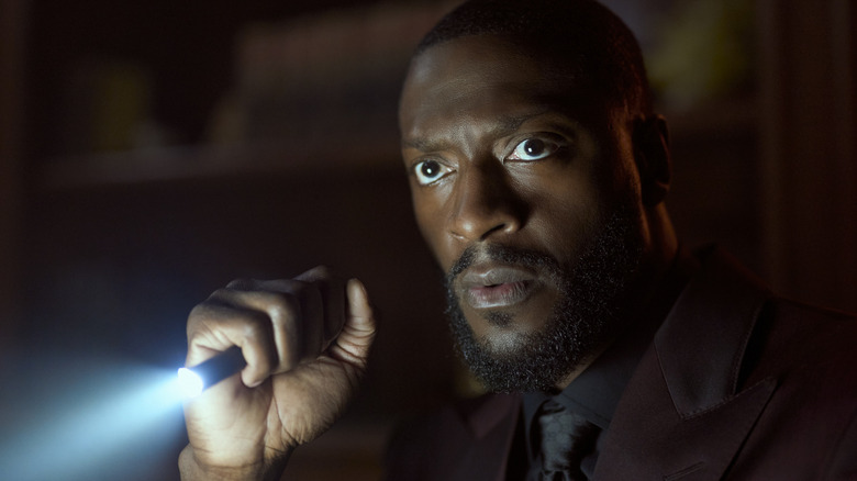 Alex Cross brandit une lampe de poche 