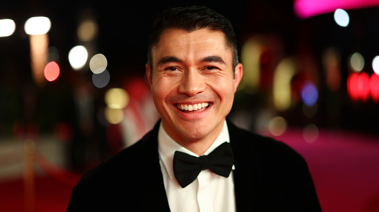 Henry Golding souriant au tapis rouge de la soirée de clôture du Festival international du film de la Mer Rouge 2025