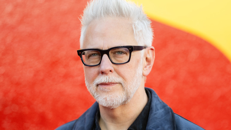 James Gunn posant devant un logo Superman lors d'un événement de fans à Londres