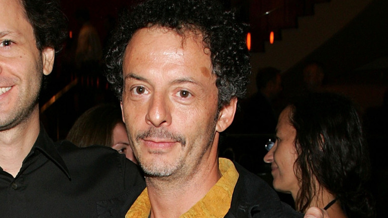 Adam Kimmel dans une veste noire avec une chemise moutarde