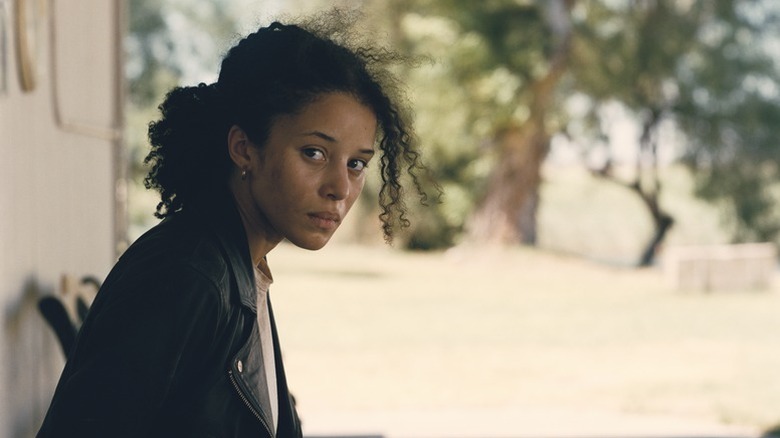 Willa regardant par-dessus son épaule, effrayée dans One Battle After Another